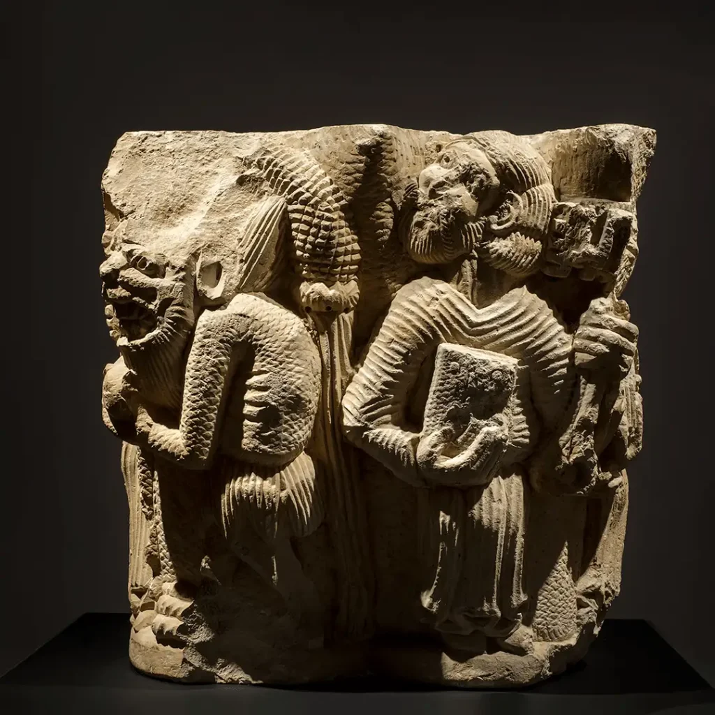 Capitel románico del siglo XIII en piedra caliza con escenas de la Anunciación, la Tentación de Jesús y San Pedro con las llaves, expuesto en el Palacio Episcopal de Segovia