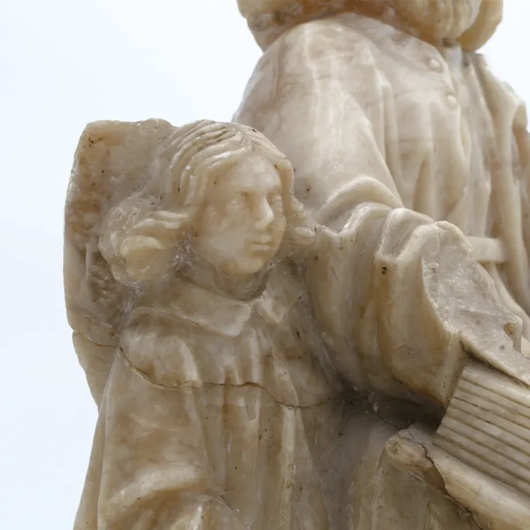 Primer plano del ángel que acompaña a San Mateo en la escultura de alabastro realizada por Sebastián de Almonacid, siglo XV.