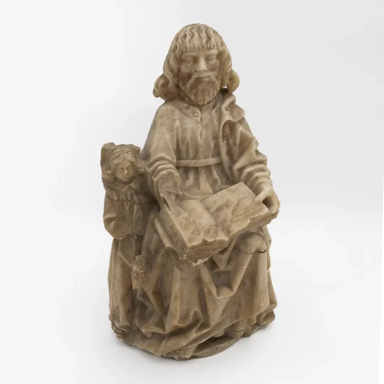Escultura en alabastro de San Mateo, siglo XV, obra de Sebastián de Almonacid, con evangelio y ángel, símbolo de su autoría sagrada.