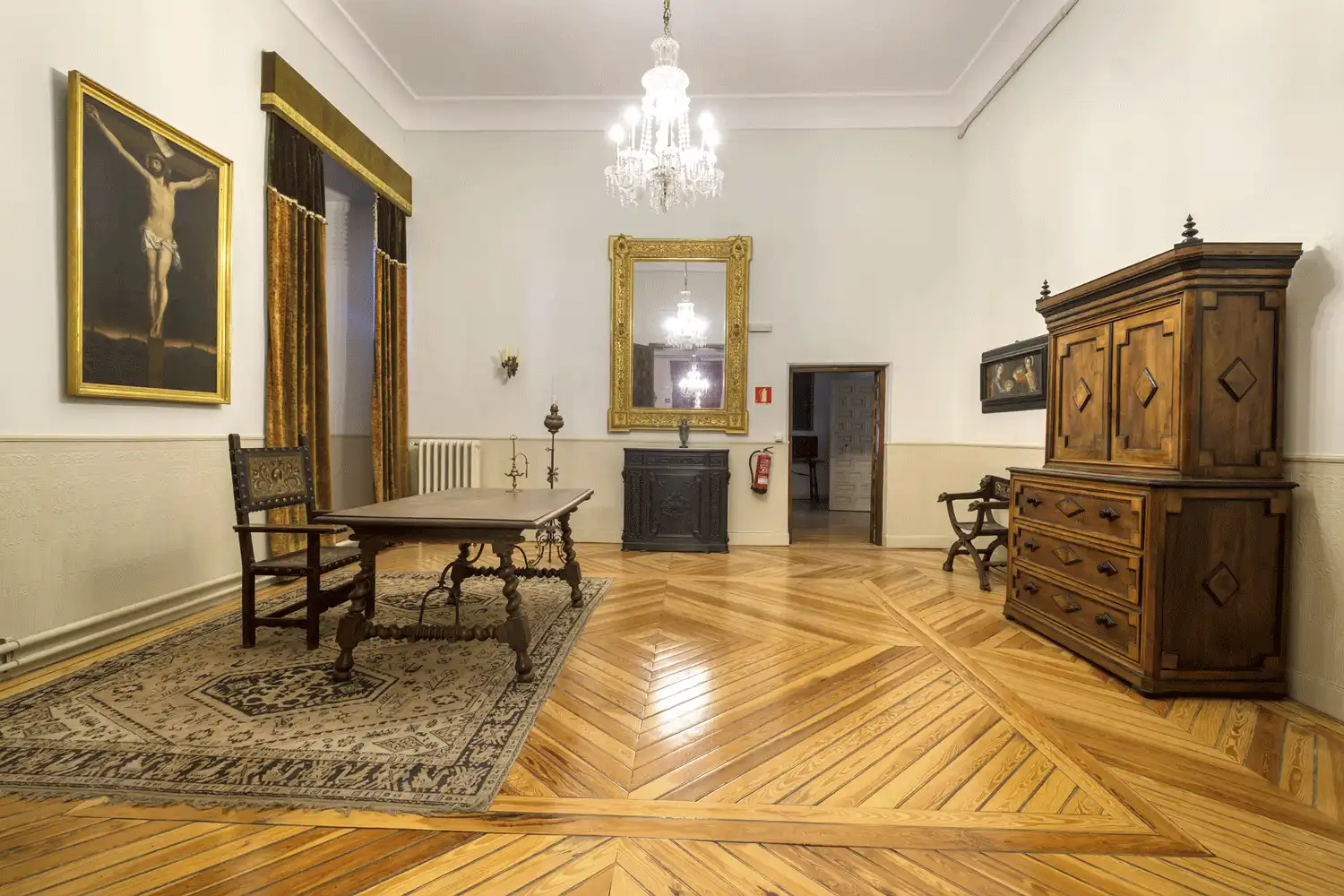 Despacho del Nuncio en el Palacio Episcopal con mesa castellana, bargueño en nogal y lienzos religiosos del siglo XVII.